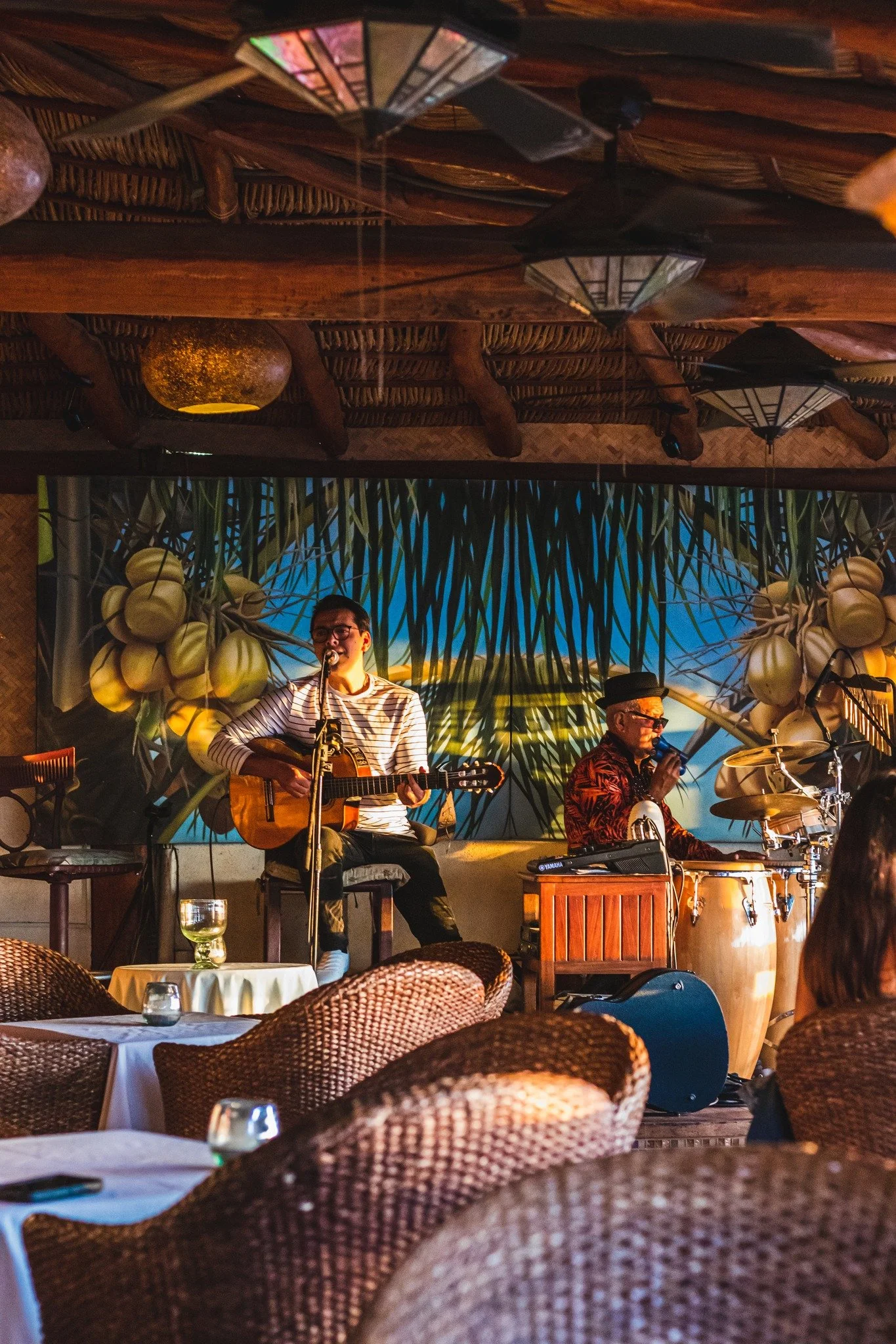 Guitarist and percussionist playing live under the palapa roof at La Palapa