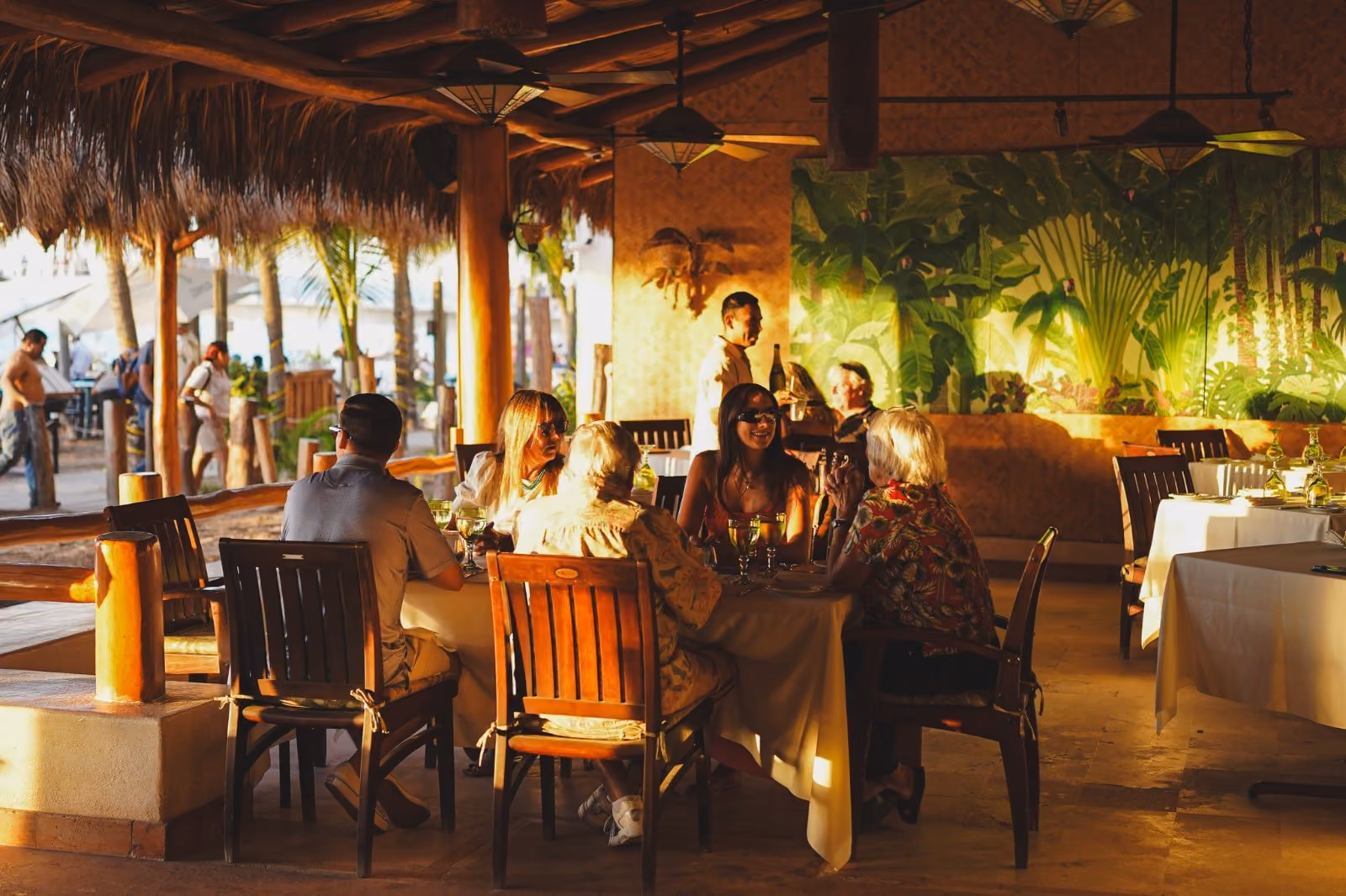 Guests dining under the palapa roof at La Palapa