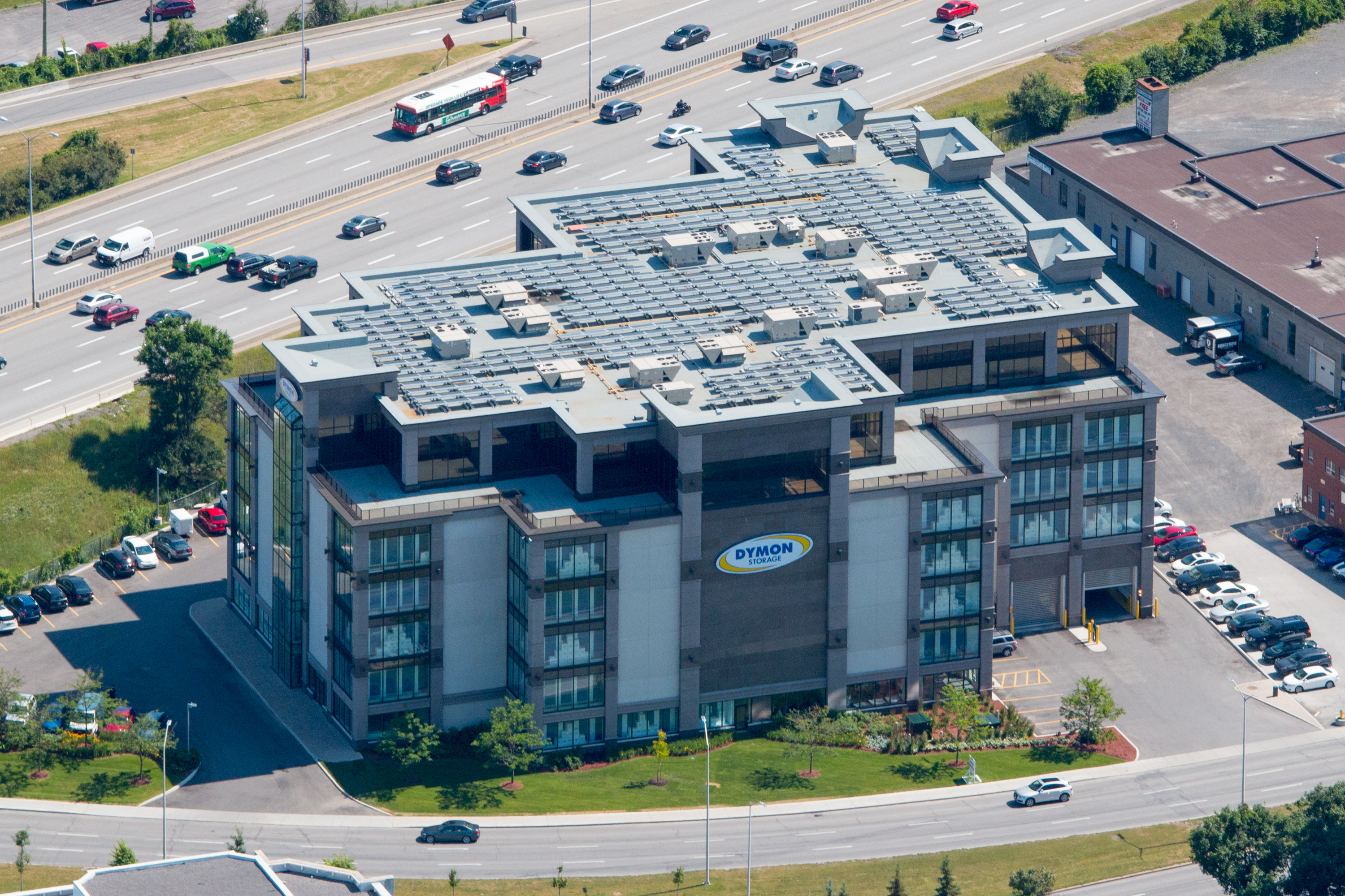 An aerial image taken on an angle that showcases Dymon Storage on Carling avenue with a rooftop of solar panels.