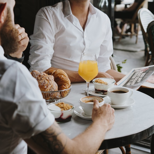 a man sitting at a table with a glass of orange juice