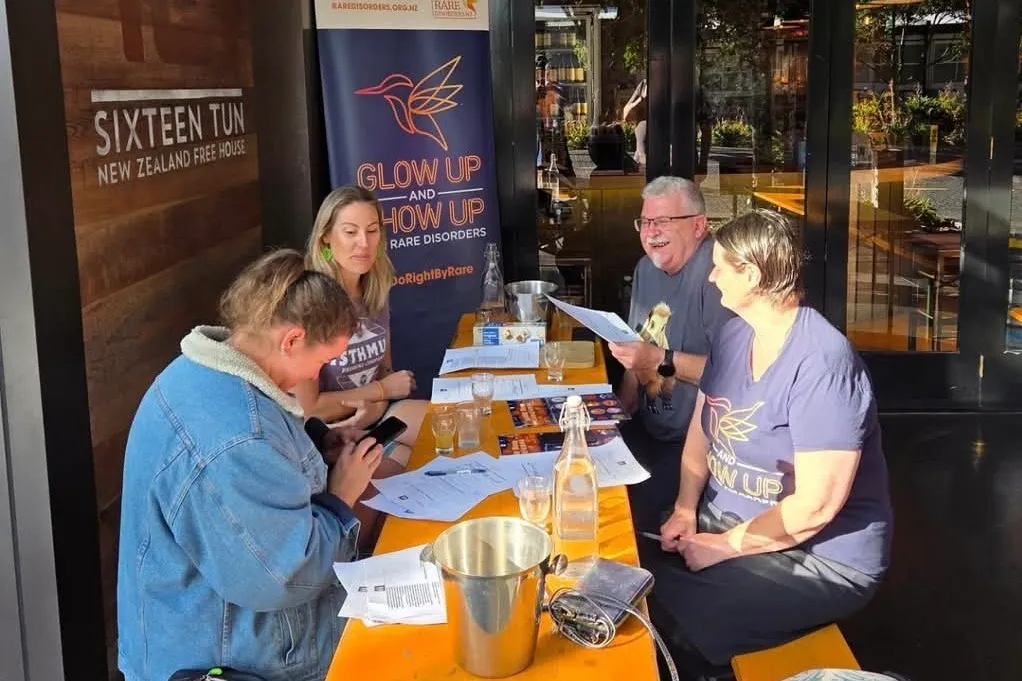 A group of people sit around a table drinking beer