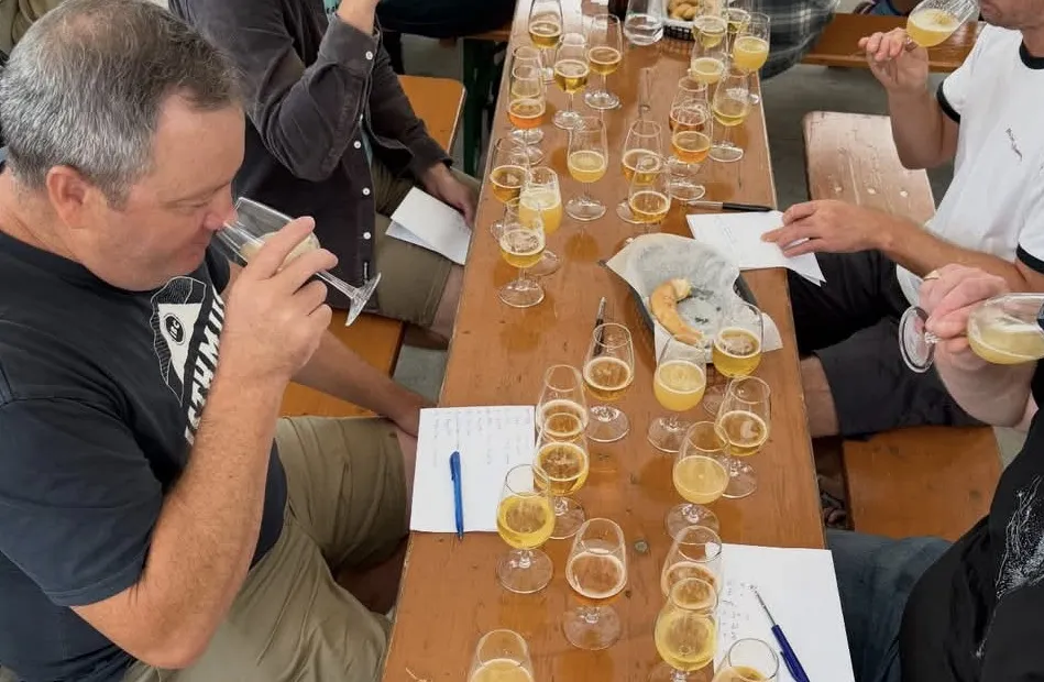 A group of people sit at a table drinking beer