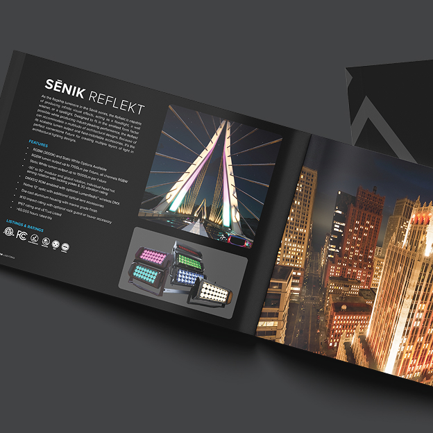 Open brochure displaying SENIK REFLEKT lighting product features, images of a lit modern bridge at night, and colorfully illuminated lighting fixtures.