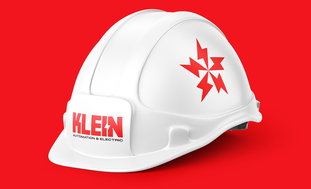 White hard hat with red Klein Automation & Electric logo and red lightning bolt design on a red background.