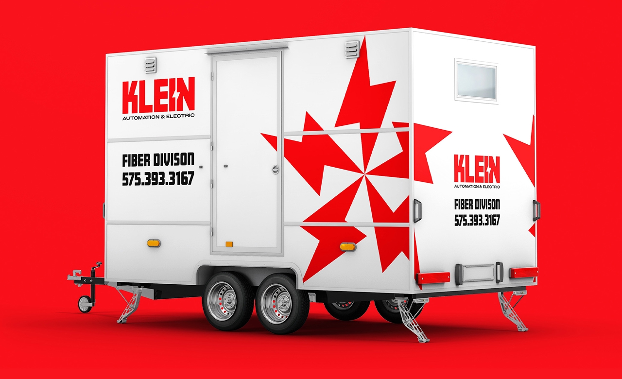White mobile trailer with red lightning bolt star graphic and text 'KLEIN Automation & Electric Fiber Division 575.393.3167' on a red background.