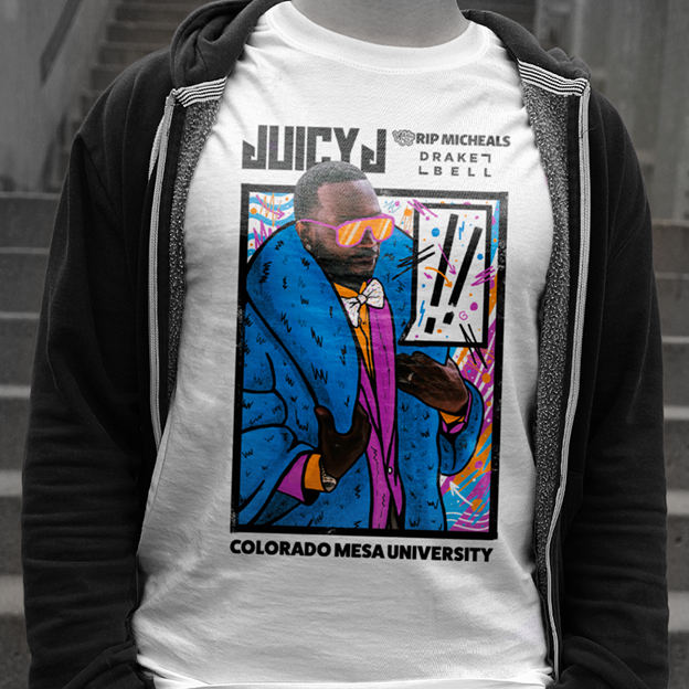 Person wearing a white T-shirt with a colorful illustration of a man in a blue coat and orange sunglasses, labeled Juicy J, along with text 'Rip Micheals Drake7 L-Bell' and 'Colorado Mesa University'.