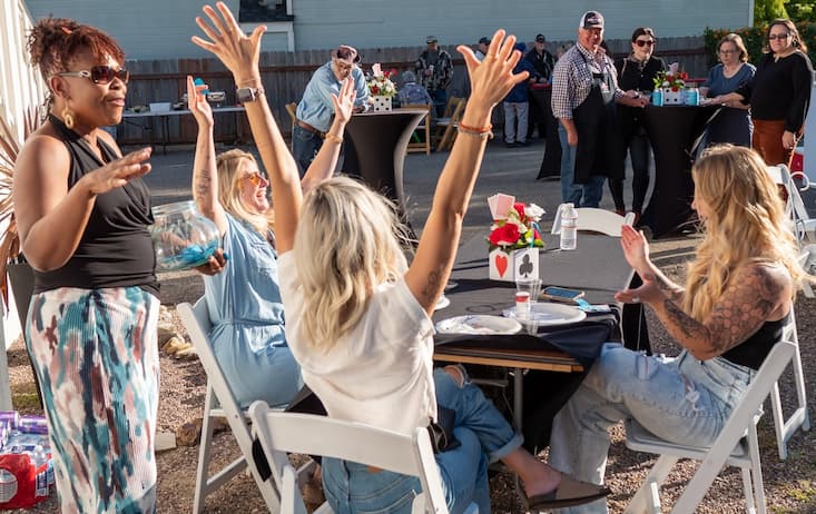 4 women celebrating at a card table