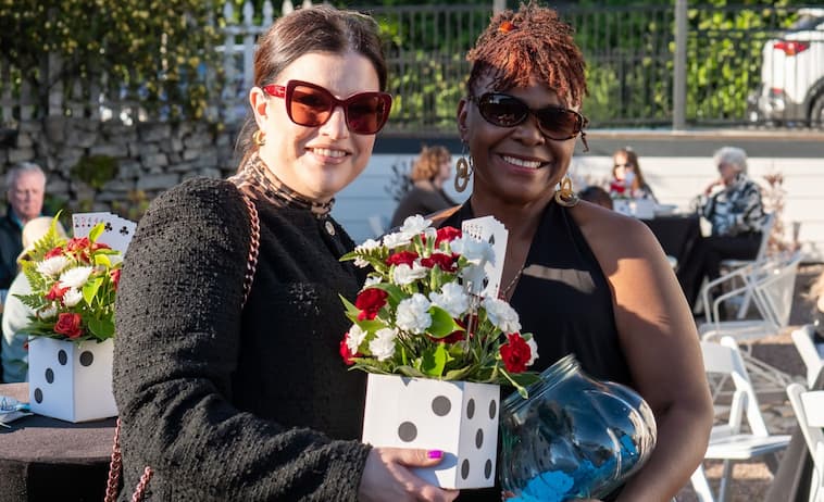Two women holding flowers and posing for the camera.