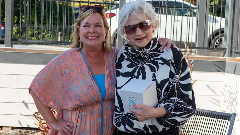 Sherri with an older client holding a Sherri Banta Group branded box.