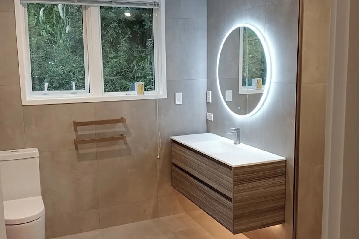 Modern bathroom with backlit oval mirror and floating timber vanity