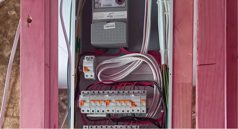 Electrical testing equipment including yellow multimeter and test probes on technical drawings