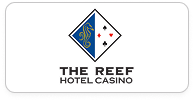 Logo of The Reef Hotel Casino featuring a blue and white diamond shape with abstract design and playing card suits.