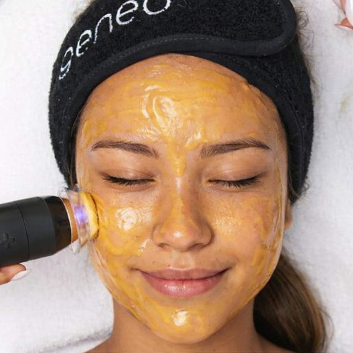 Geneo X facial in progress, gold treatment mask applied to a client's face