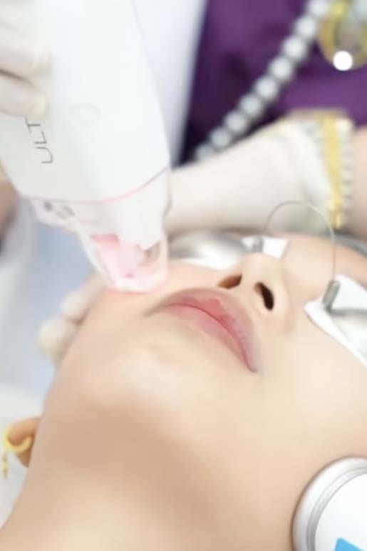 Skin treatment with a handheld device across a client's cheek and nose
