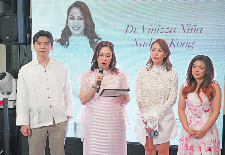 Speakers on stage beside a banner for Dr Vinizza Nina Nadela Kong