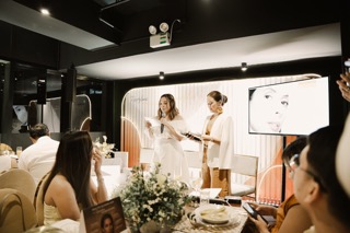 Presenter speaking to guests at a Restylane Skinboosters event