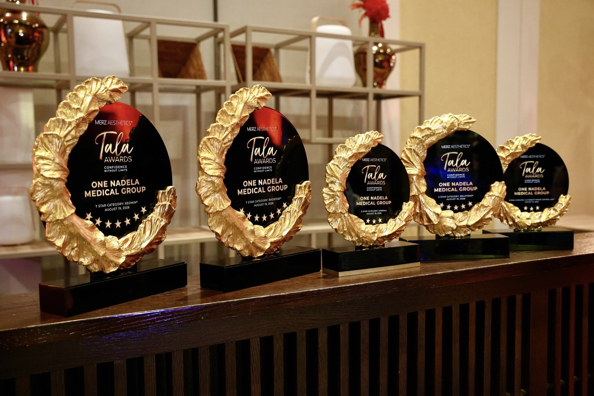 Five Merz Aesthetics Tala Award trophies engraved with One Nadela Medical Group.