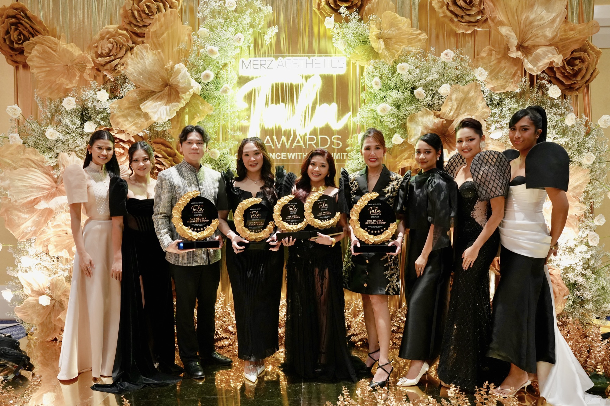 The One Nadela Medical Group team with the five awards at the Tala Awards backdrop.