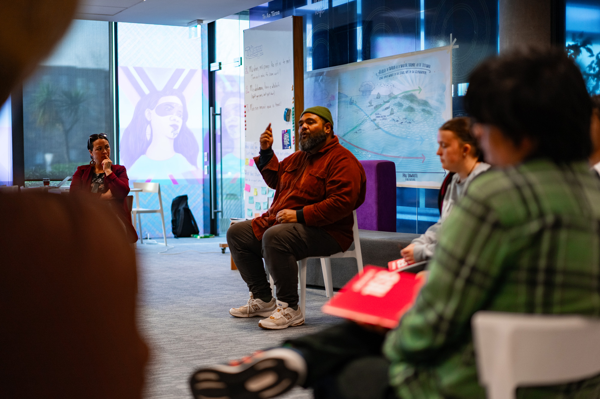 Man presents to a room of rangatahi at a Kōkirihia workshop.