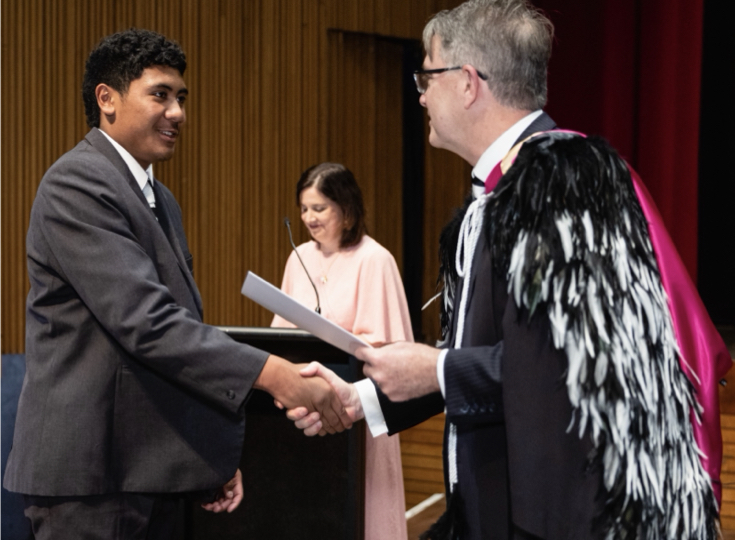 Christs' College student shakes a teachers hand.