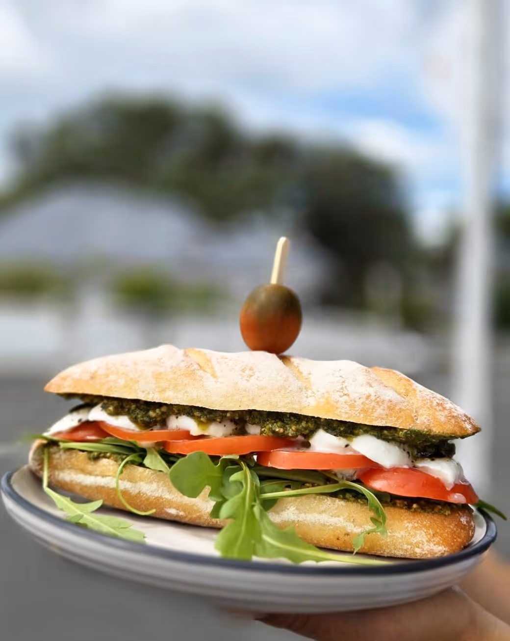 Person enjoying a sandwich at a café in Devonport, Auckland, New Zealand