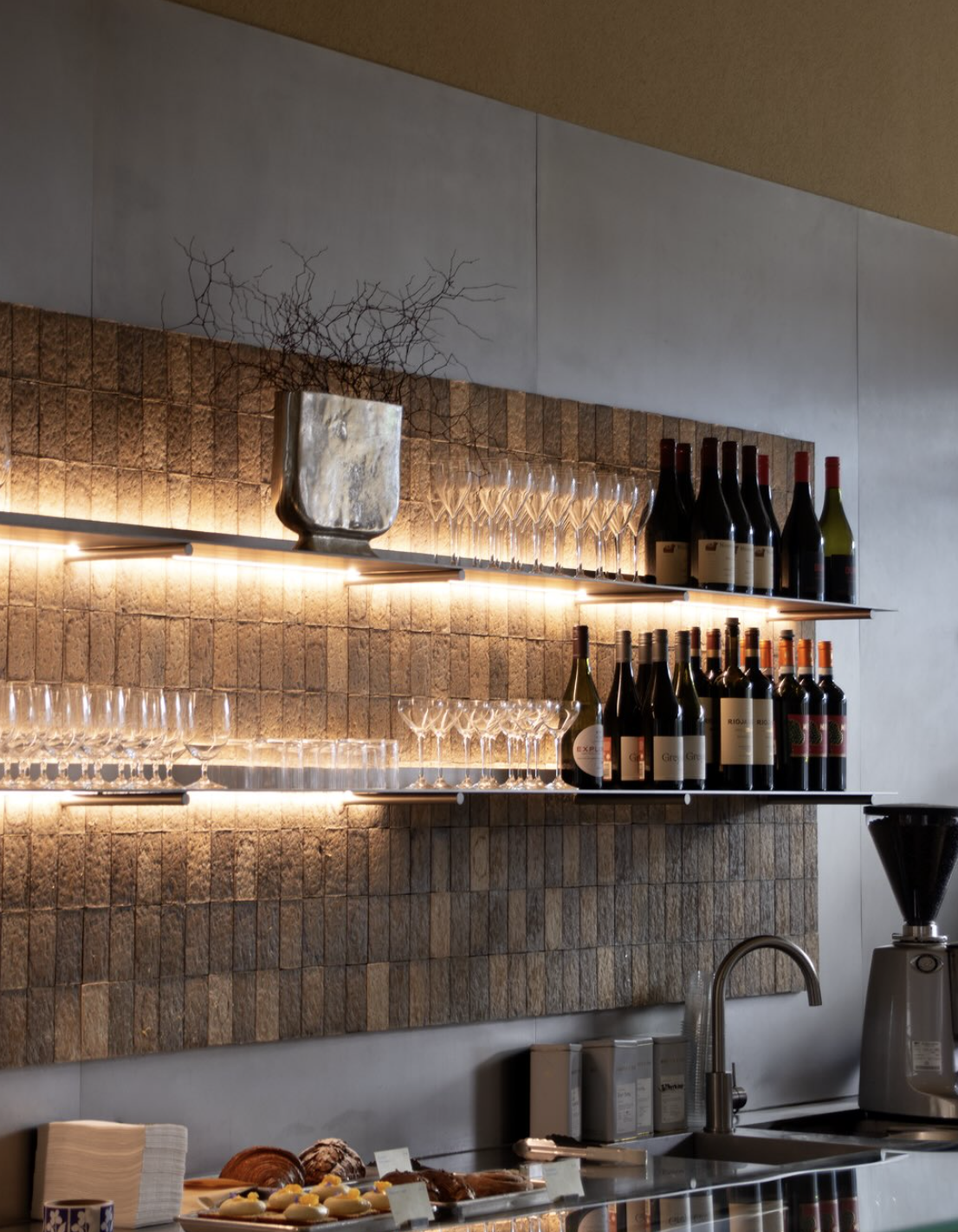 Behind the bar at Mother café in Grey Lynn, Auckland, featuring an espresso machine, a curated wine selection, and a warm, contemporary interior.