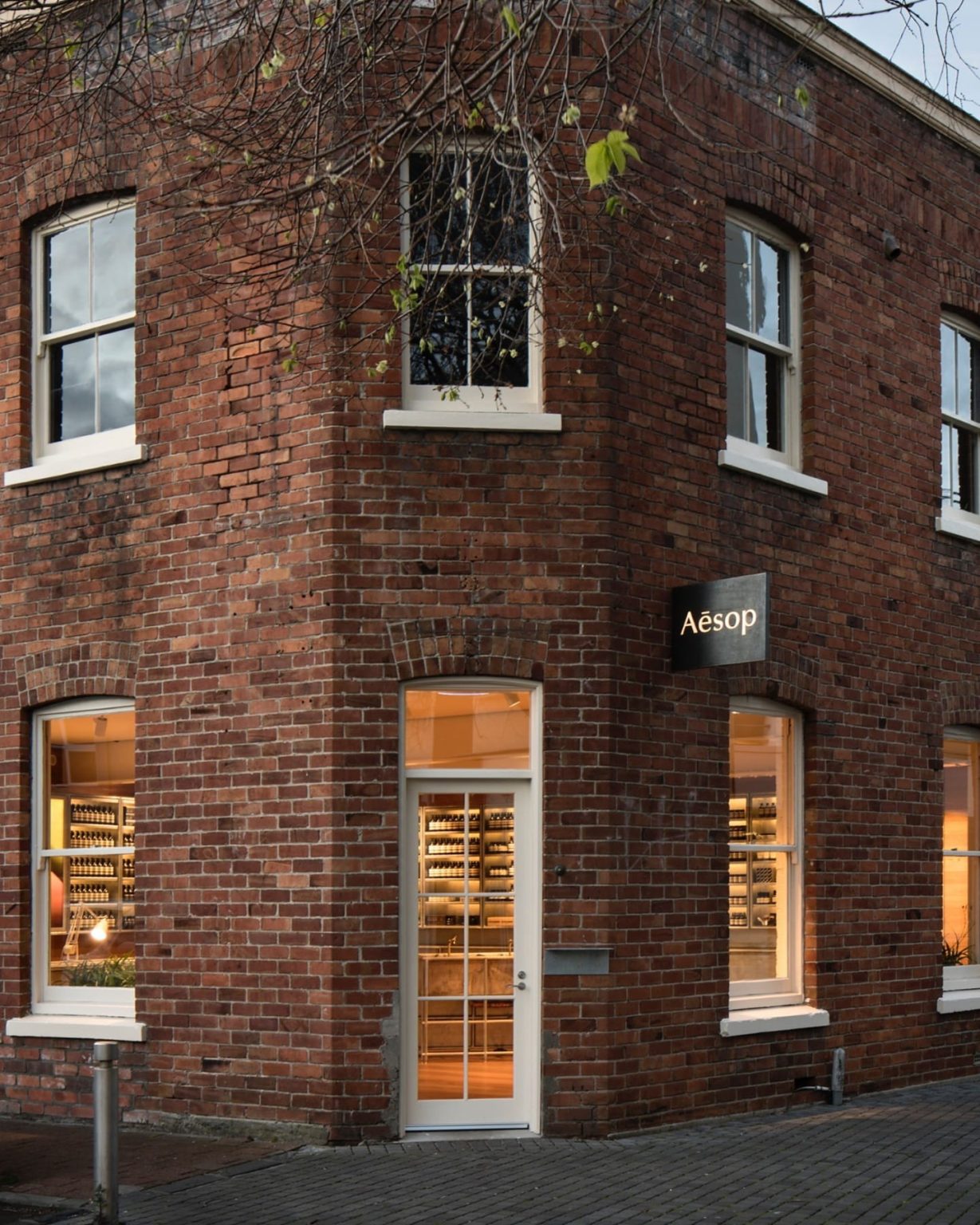 Exterior of the Aesop store in Newmarket, Auckland, featuring a distinctive brick façade, large display windows, and a minimalist retail design.