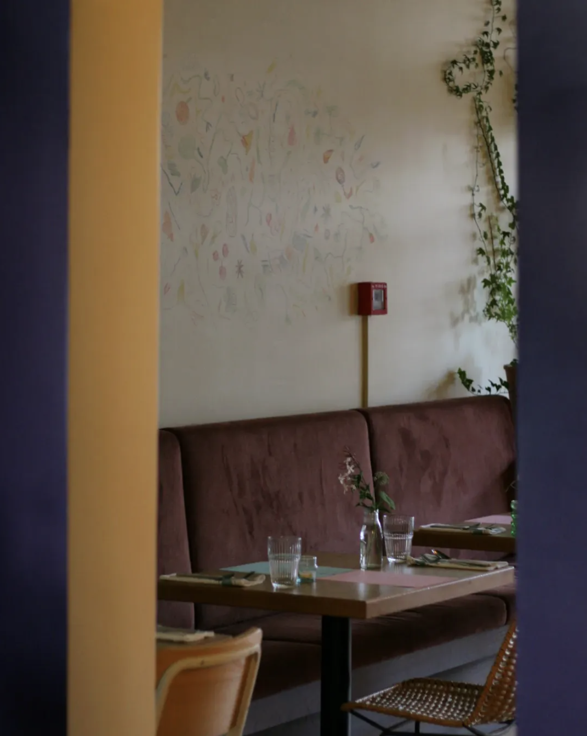 Dining table at Forest in Mt Eden, Auckland, featuring purple velvet seating, contemporary interiors, and foliage-inspired table décor.