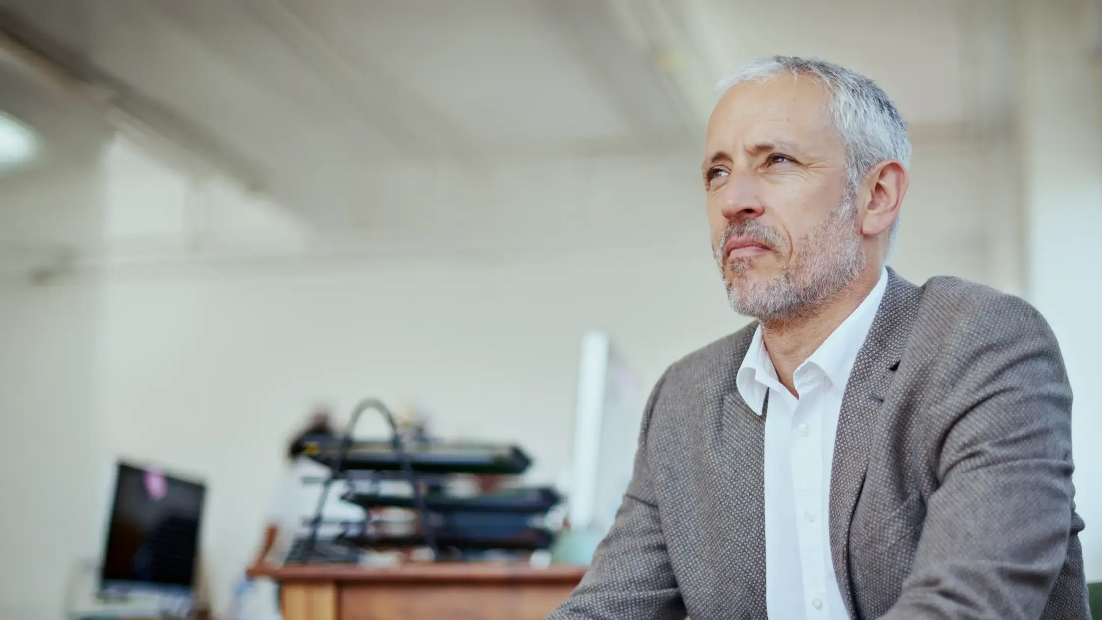 A man sitting in a chair looking off into the distance.