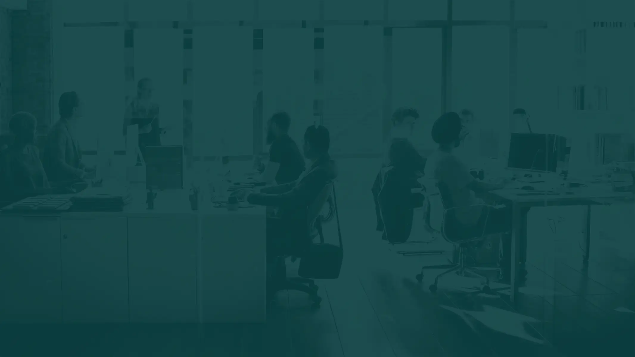 A group of people sitting at desks in an office.