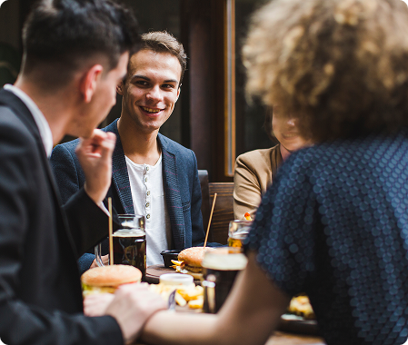A group of people sitting around a table eating food.