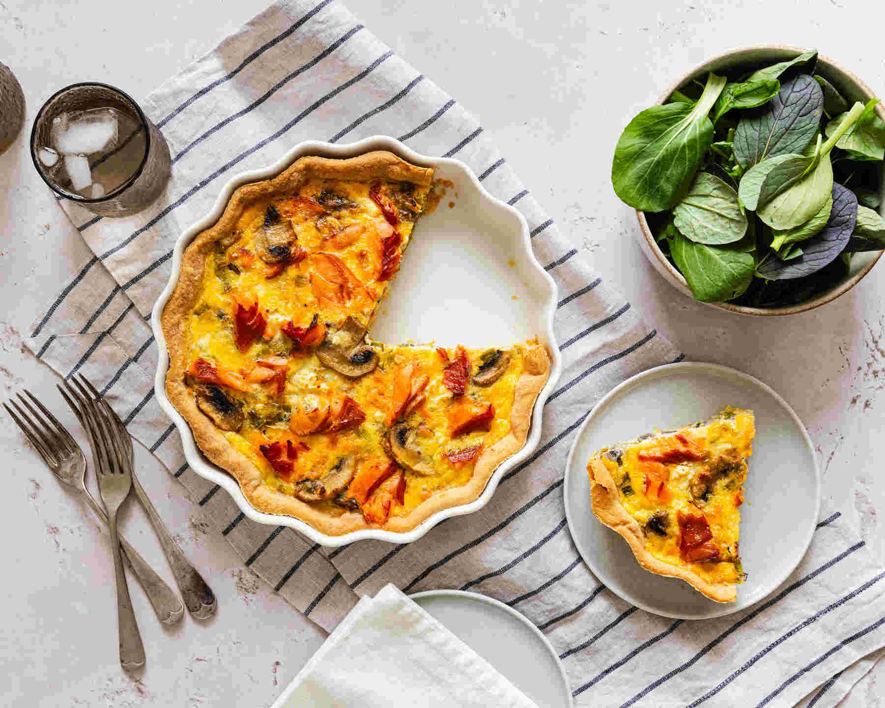 Sliced mushroom and Aoraki smoked salmon quiche with a golden crust