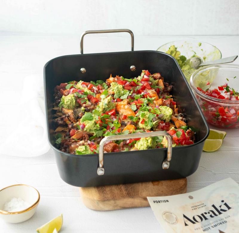 A plate of nachos with Aoraki smoked salmon, avocado, tomato
