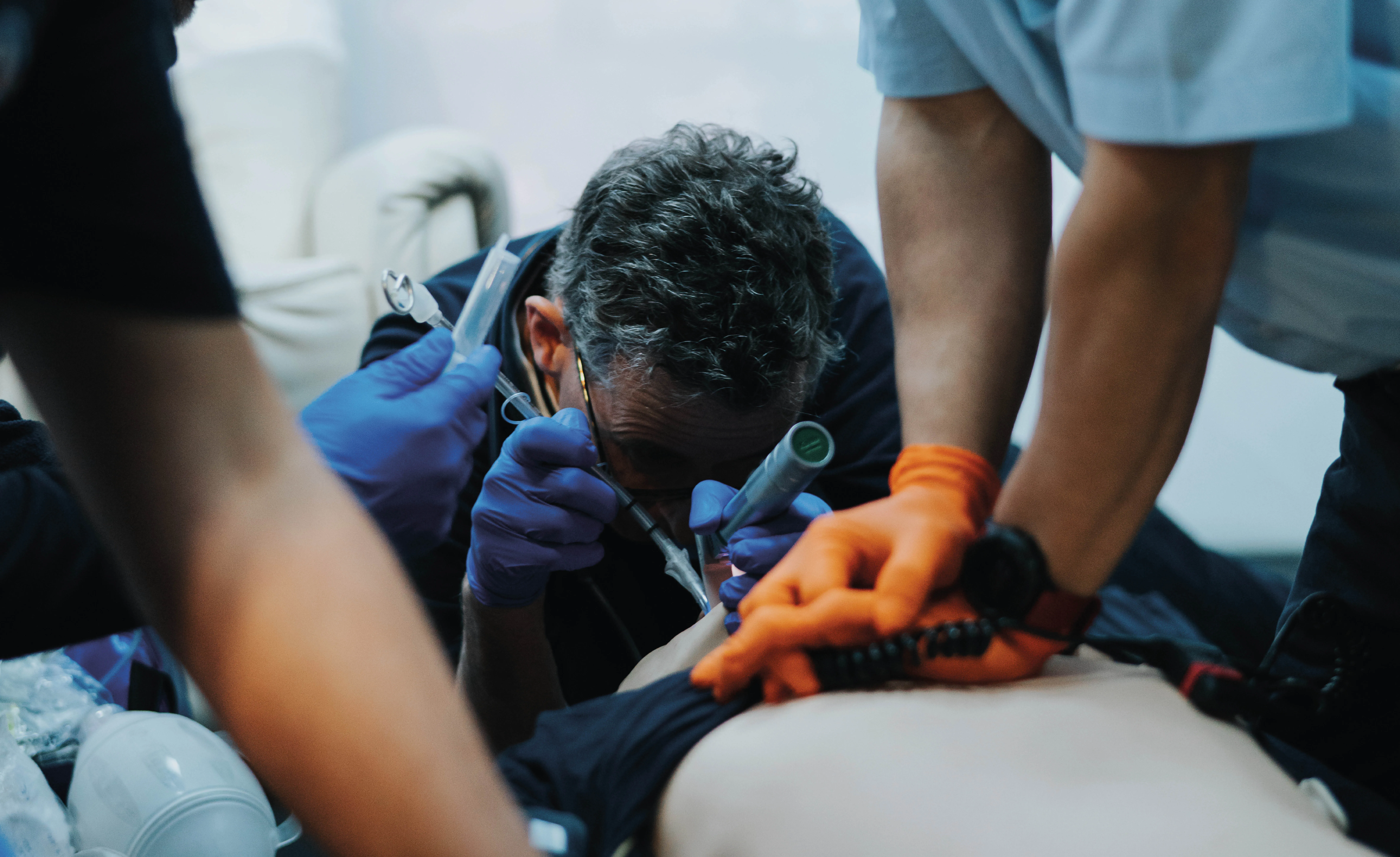 Les intervenants médicaux d'urgence pratiquent la RCP et l'intubation sur un patient allongé sur une surface plane.