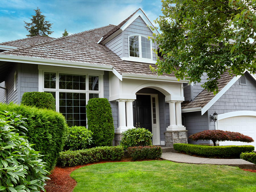 Front view of a gray suburban house with arched entry