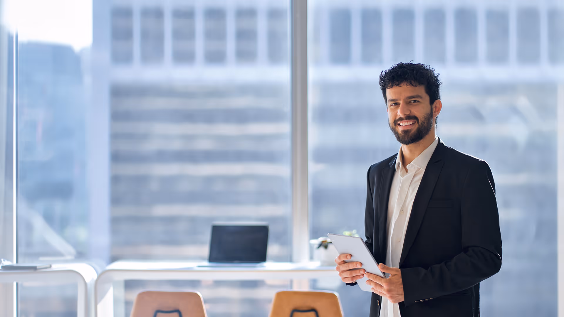 Smiling man in an office holding a pack of documents