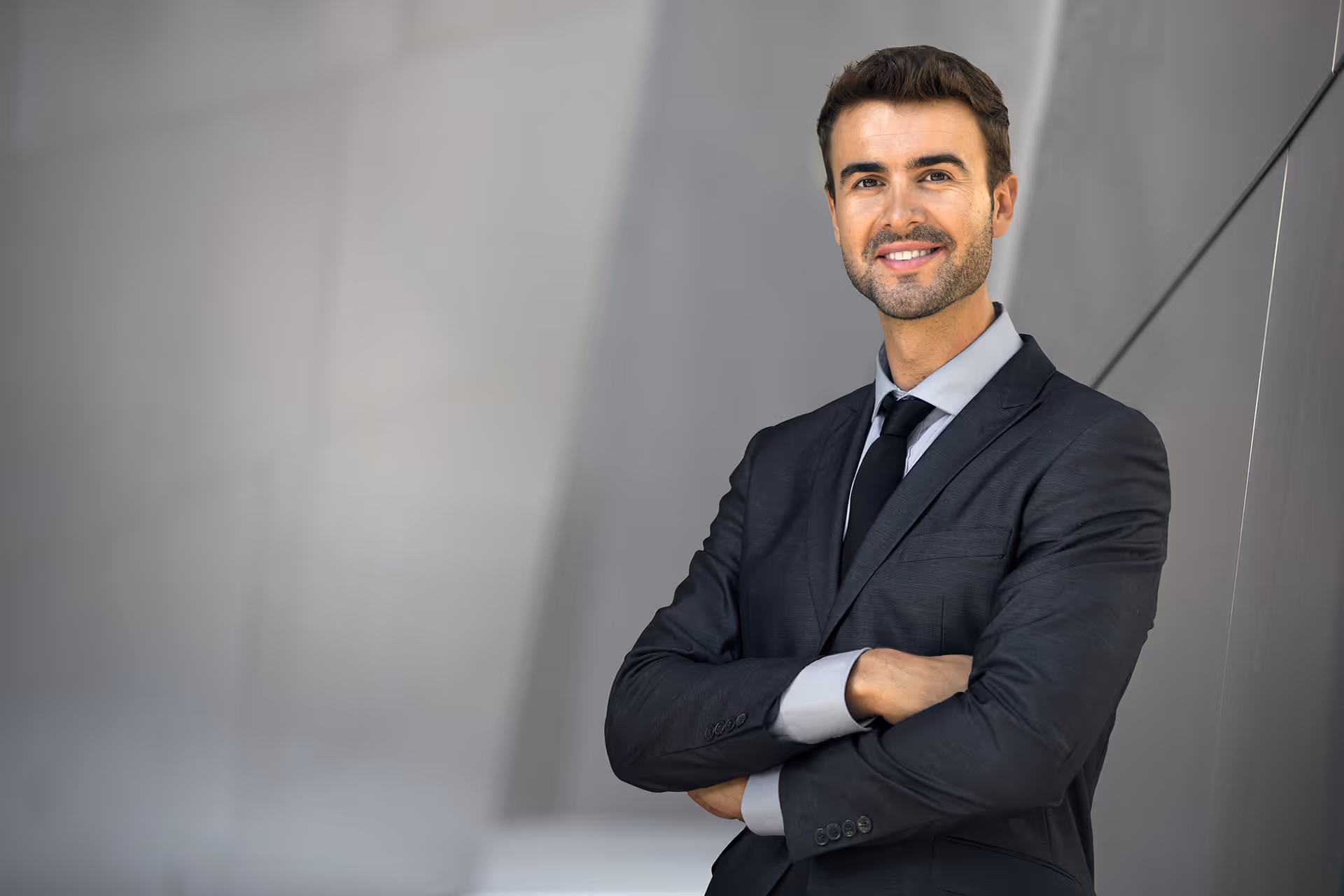 A man smiling and looking at the camera with folded arms