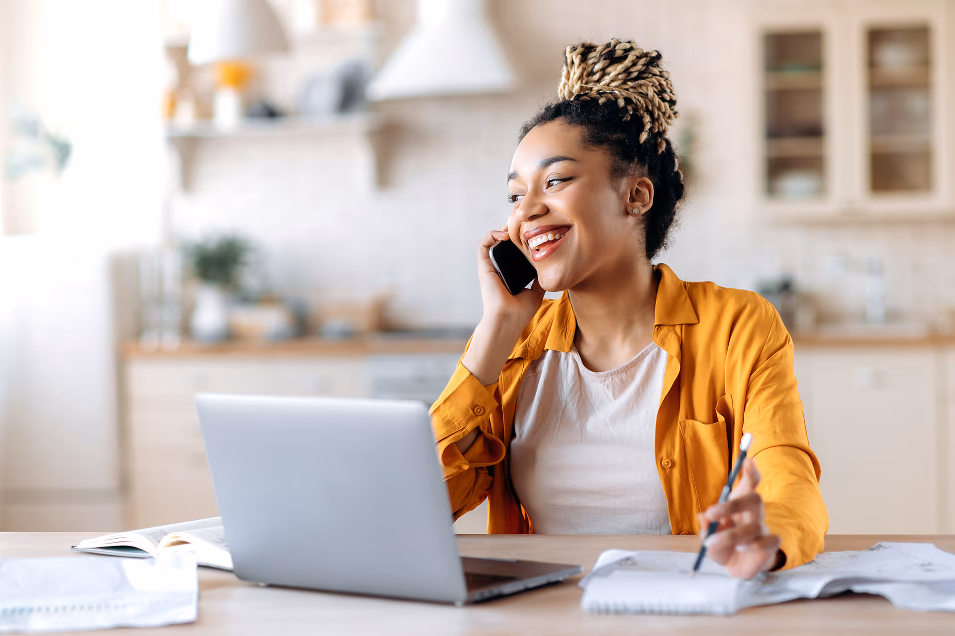 A woman making notes in a notebook during a phone call