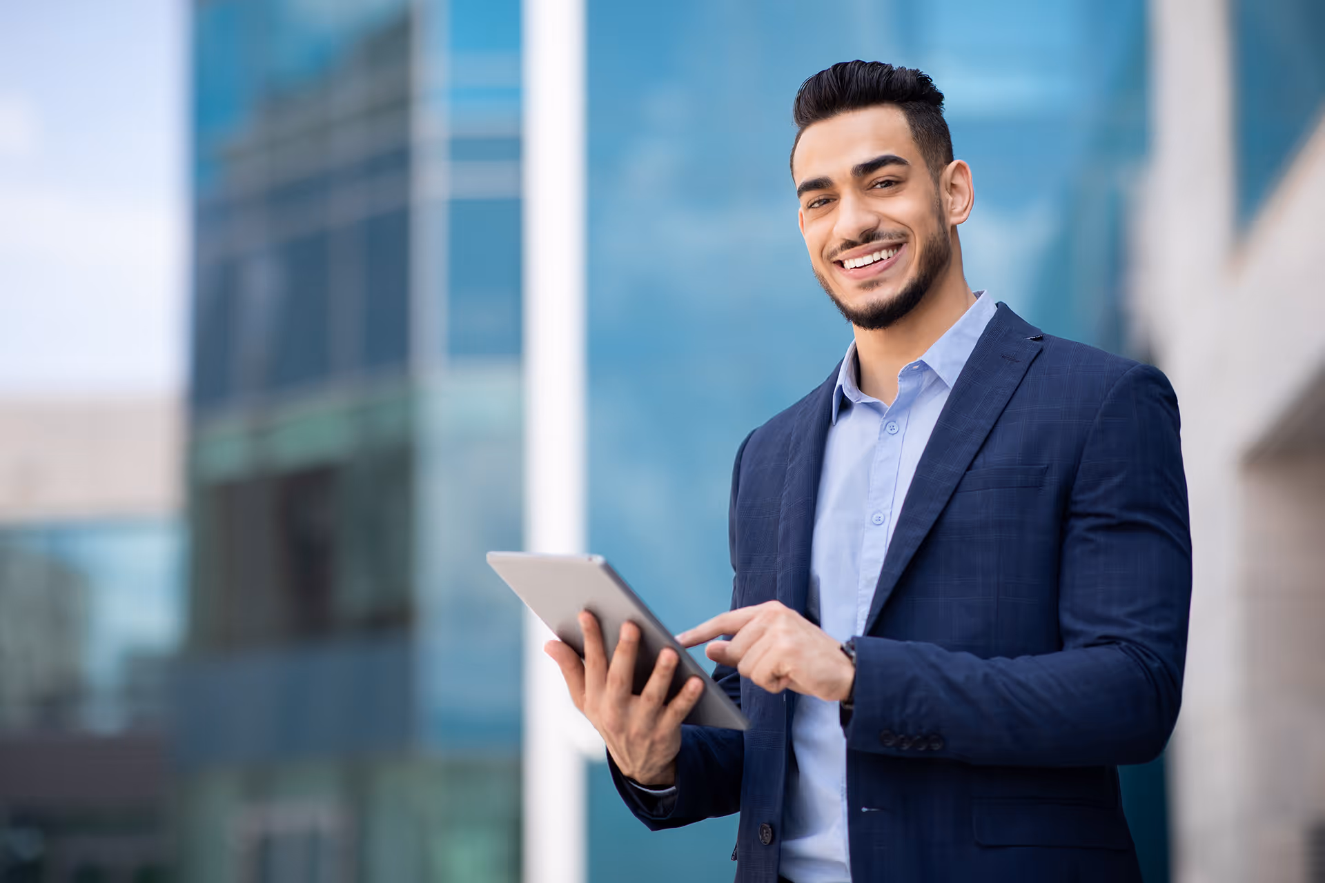 Man smiling whilst using a tablet