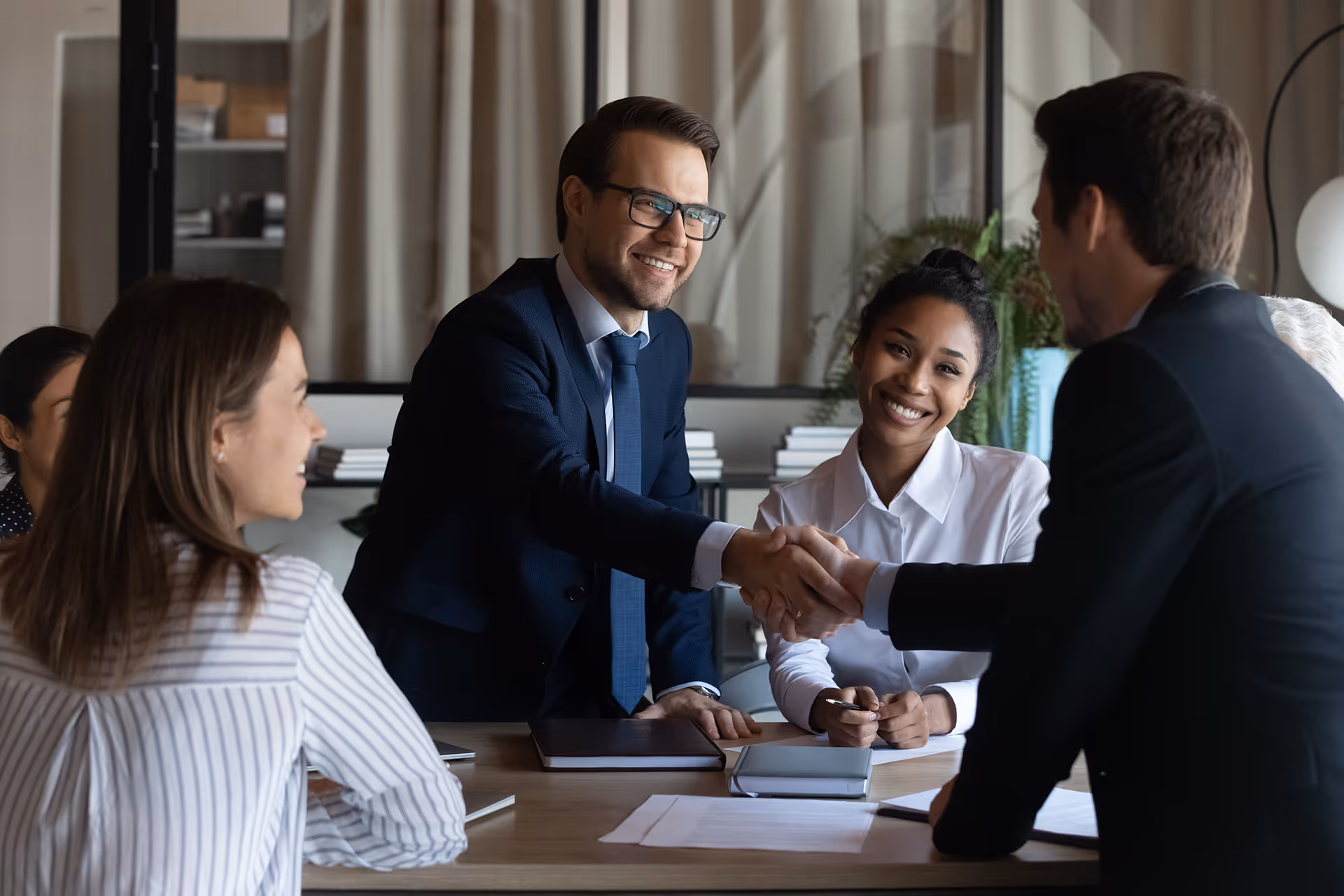 People shaking hands during a meeting — representing insurance solutions for travel agents