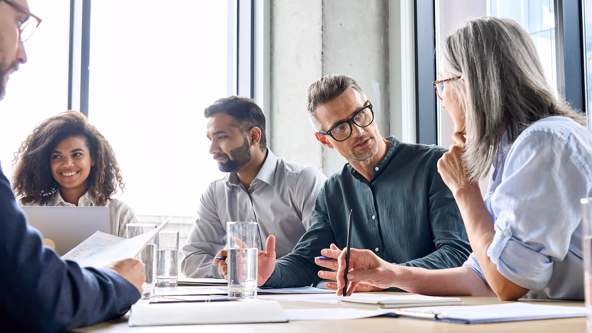 People chatting during a work meeting — representing financial failure insurance