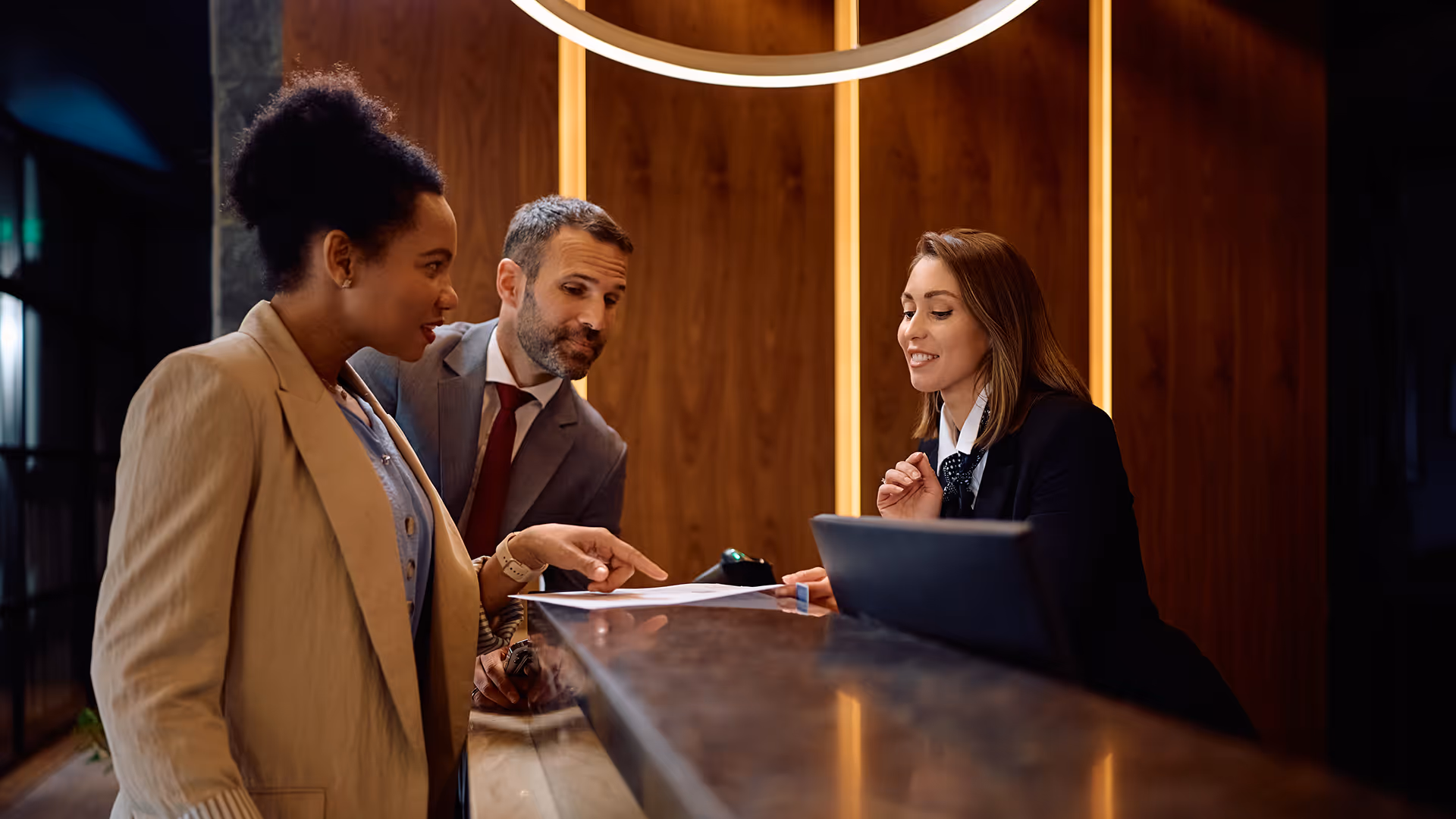 Hotel receptionist discussing paperwork with guests