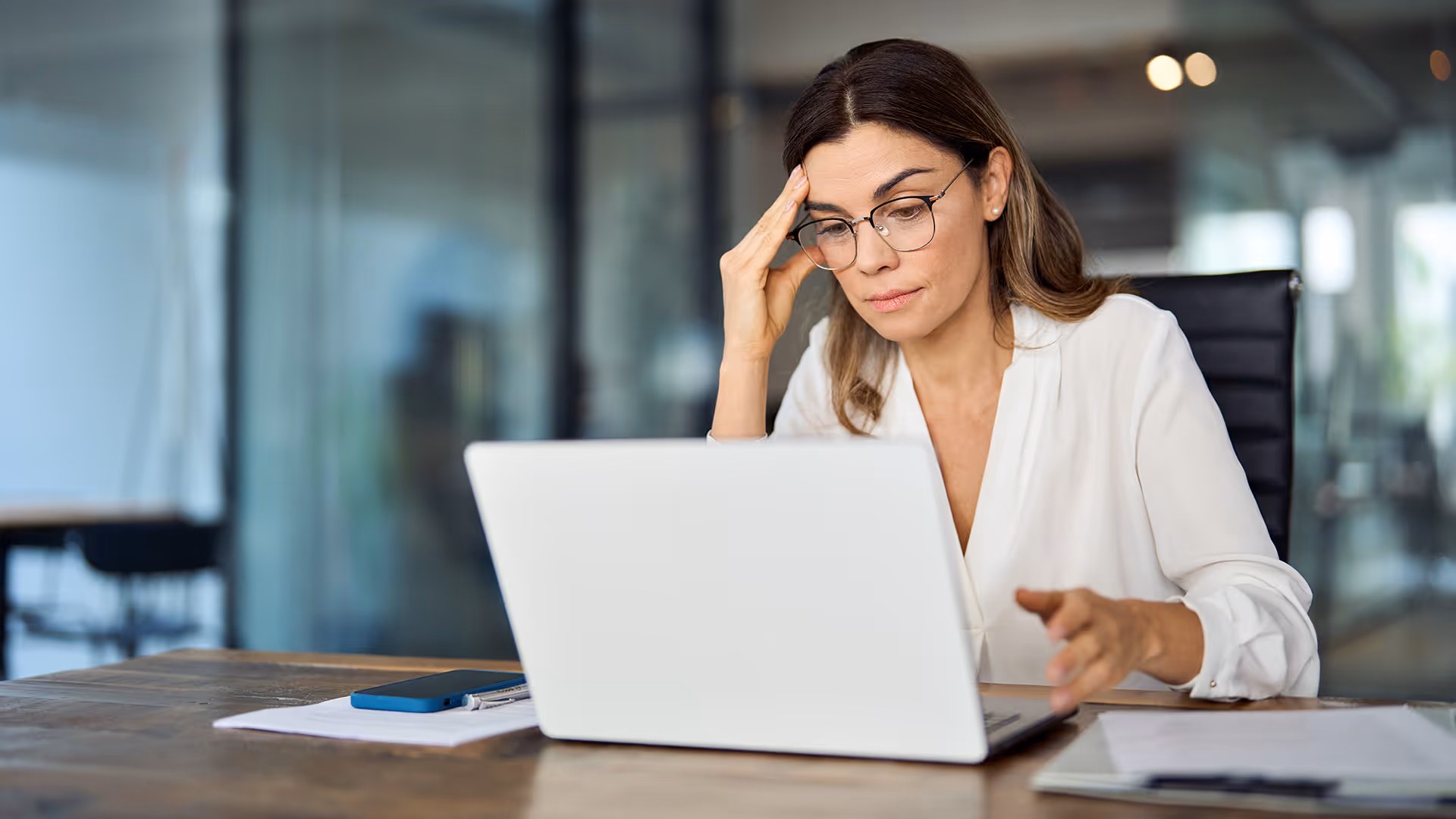 Stressed businesswoman assessing finances on a laptop