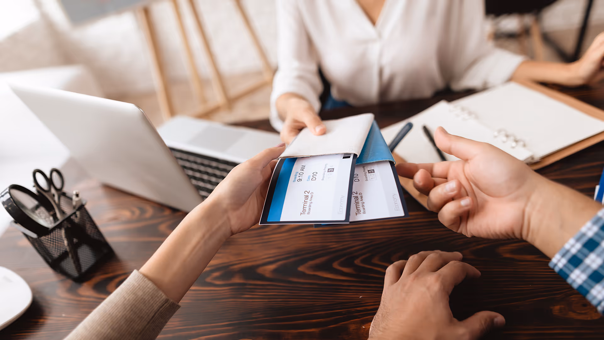 Travel agent handing flight tickets to a client