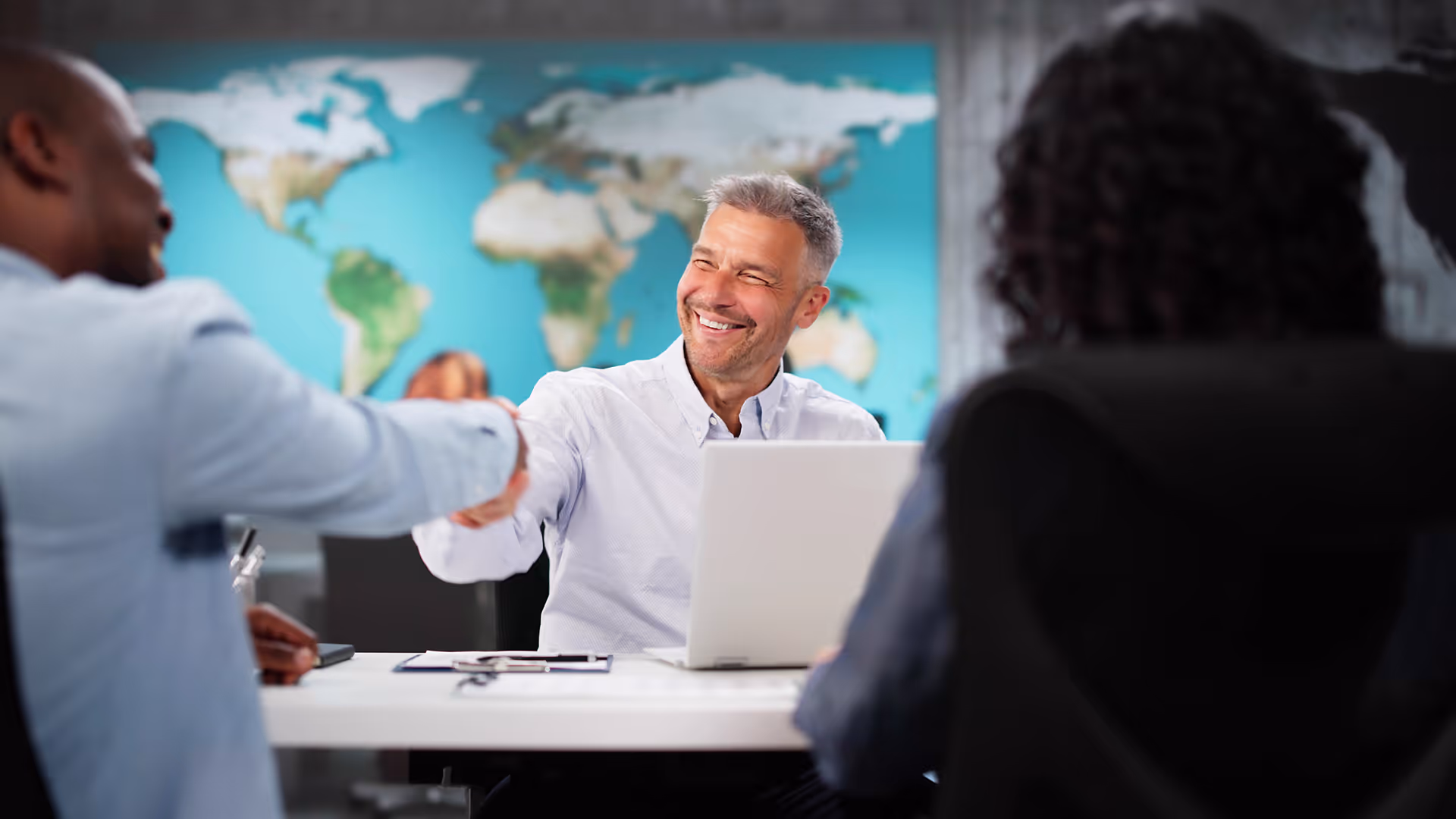 Travel agent shaking hands with a customer