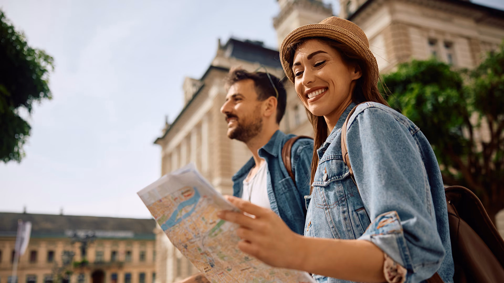 Couple looking at a map whilst walking through a city