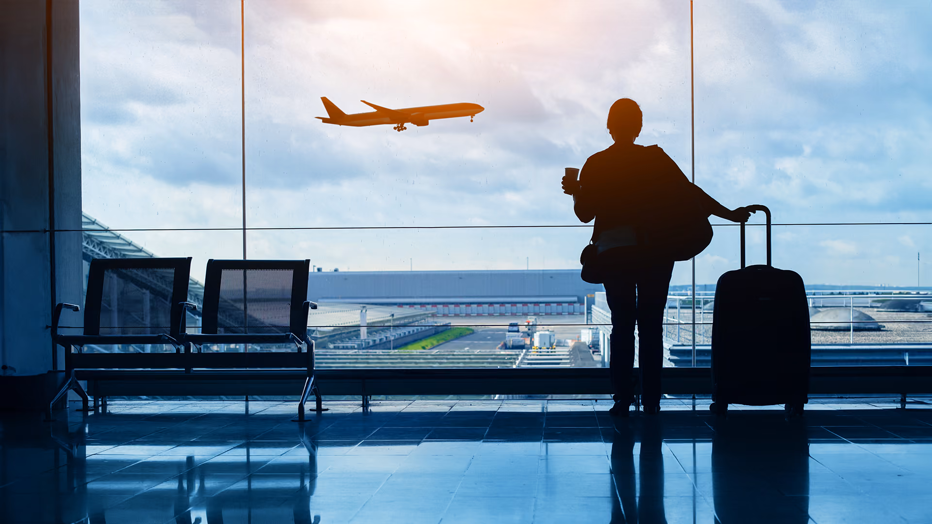 Traveller in an airport watching a plane taking off