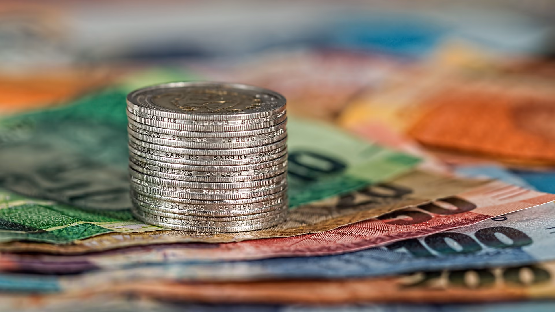 A stack of coins on a pile of euro notes, representing secure cash reserves
