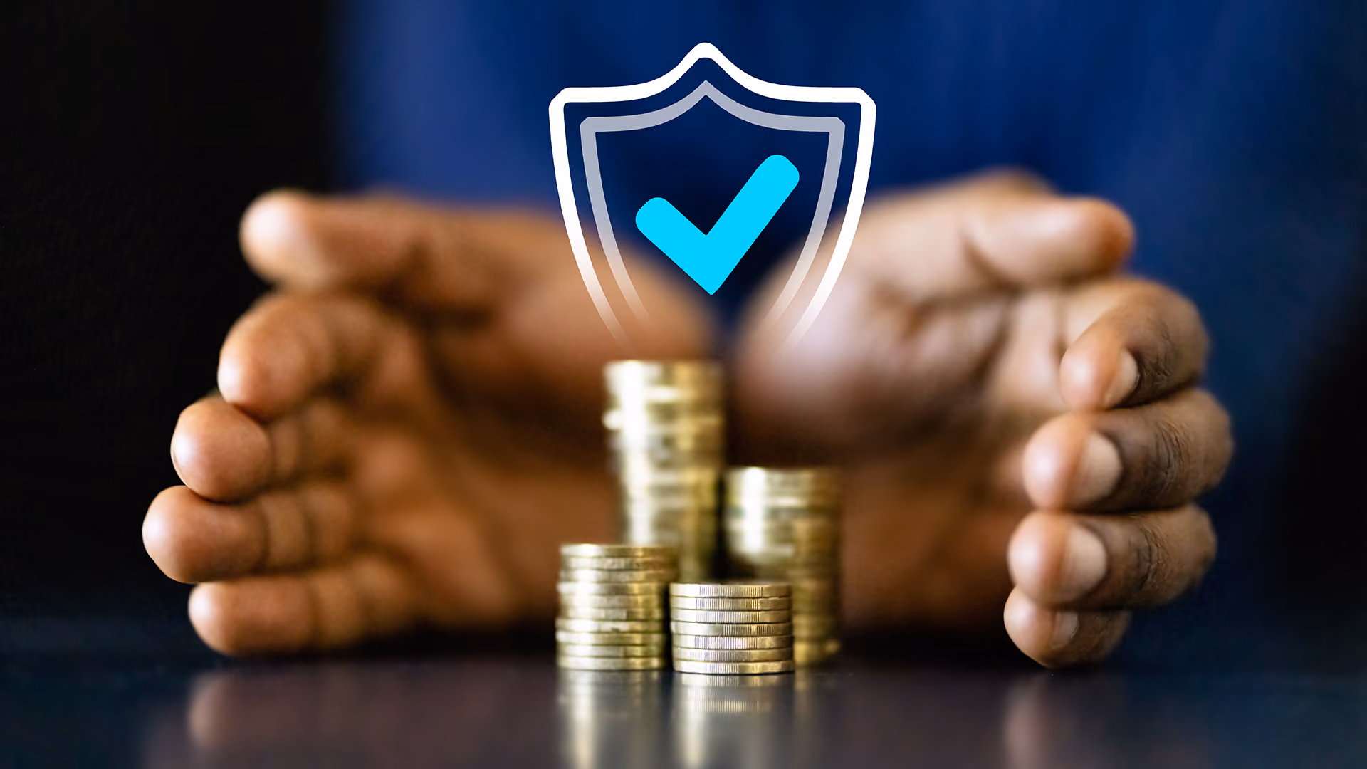Hands and coins with a shield overlaid, representing insurance