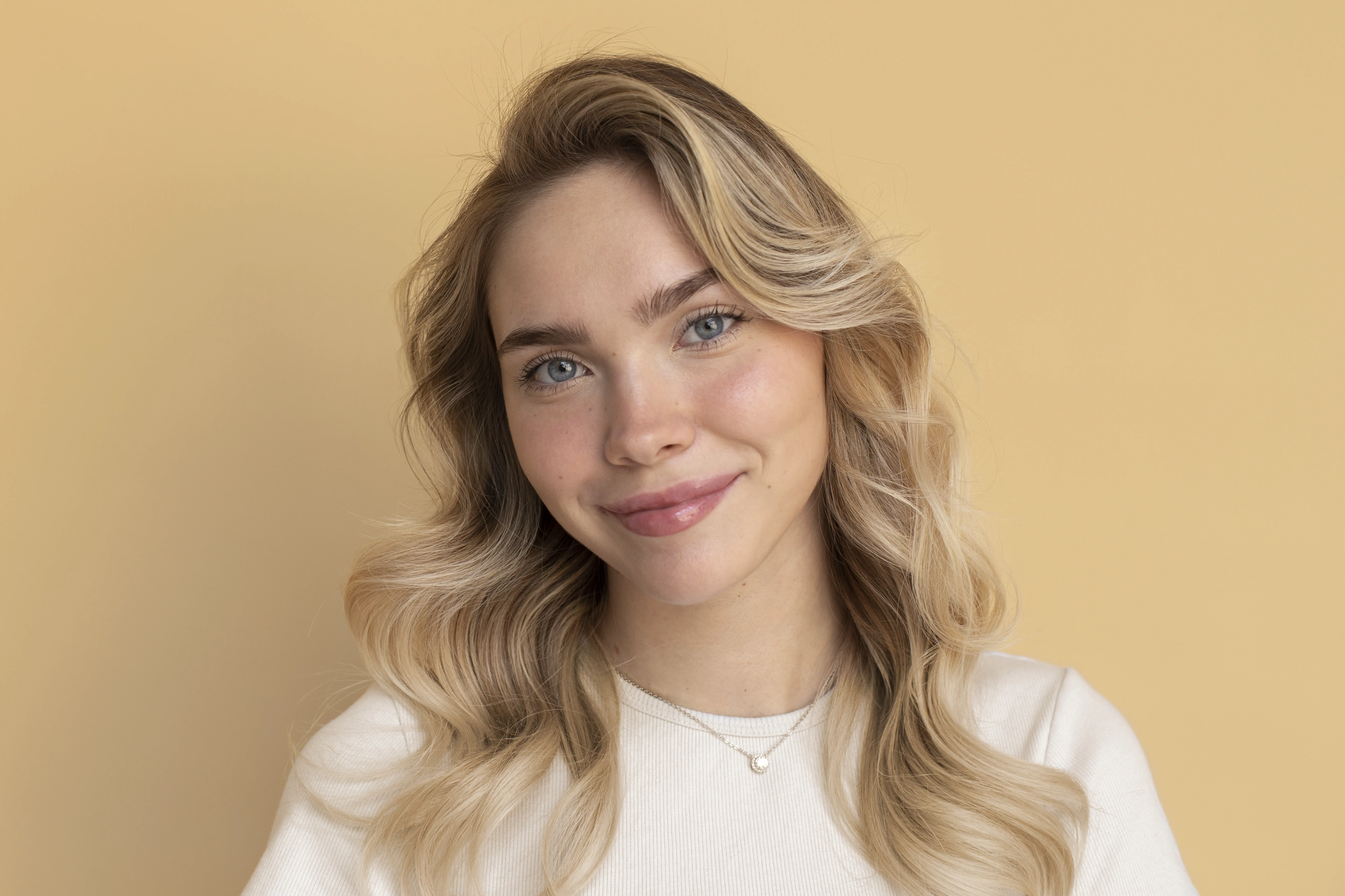 A woman with blonde hair and a white shirt.